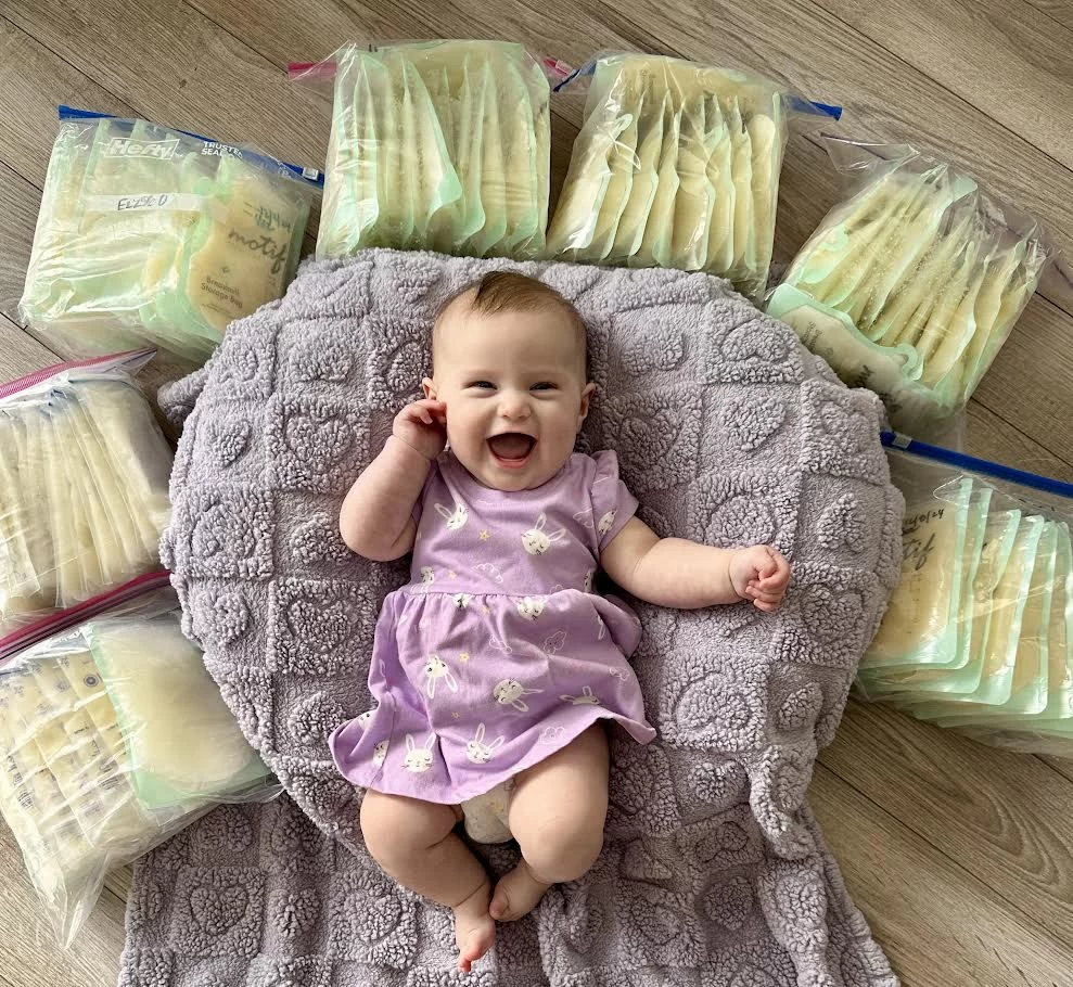 Happy baby with storage bags of milk